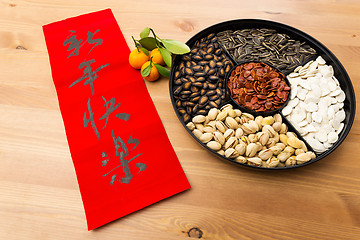 Image showing Chinese new year snack tray and chinese calligraphy, meaning for