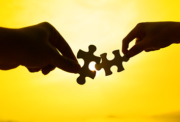 Image showing Silhouette of two hands connect puzzle together