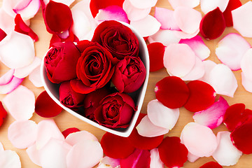 Image showing Beautiful Red rose inside the heart shape bowl with petal beside