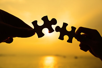 Image showing Silhouette of two hands connect jigsaw together