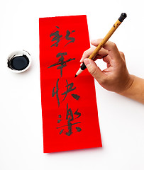 Image showing Writing of chinese new year calligraphy, phrase meaning is happy