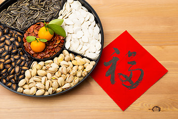 Image showing Traditional Lunar new year snack tray and chinese calligraphy, m