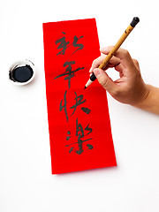 Image showing Writing of chinese new year calligraphy, phrase meaning is happy