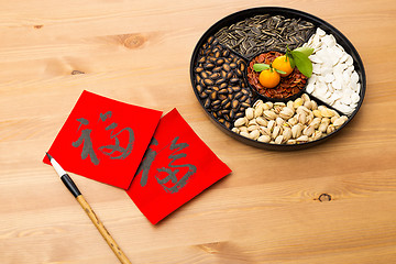 Image showing Chinese new year snack tray and chinese calligraphy, meaning for