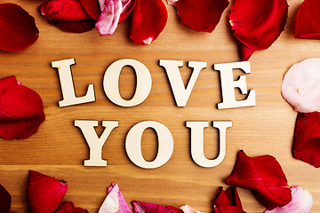 Image showing Love you wooden text and rose petal