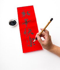 Image showing Writing of chinese new year calligraphy, phrase meaning is happy