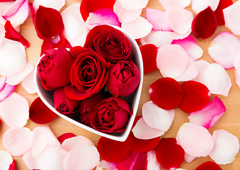 Image showing Rose flower inside heart shape bowl with petal beside 