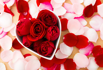 Image showing Beautiful Red rose inside the heart shape bowl with petal beside