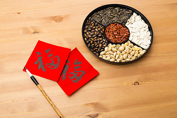 Image showing Chinese new year snack tray and chinese calligraphy, meaning for