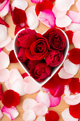 Image showing Beautiful Red rose inside the heart shape bowl with petal beside