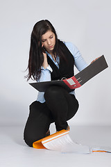 Image showing Young woman is squatting and phone