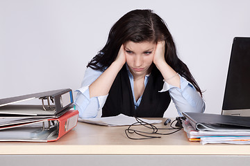 Image showing Young female office worker at desk