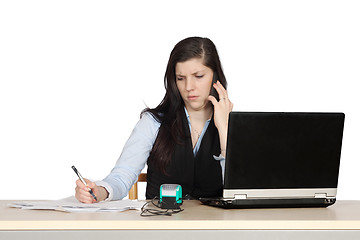 Image showing Young woman behind a desk phone