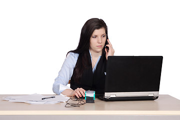 Image showing Young woman behind a desk phone