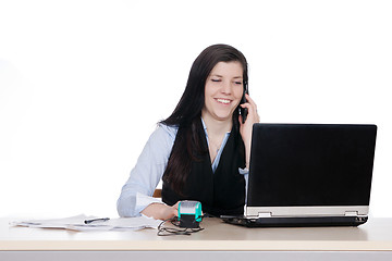 Image showing Young woman behind a desk phone