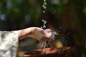 Image showing splashing fresh water on woman hands