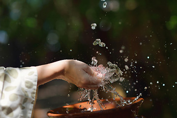 Image showing splashing fresh water on woman hands