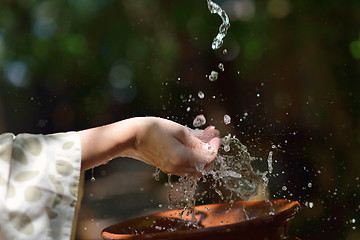 Image showing splashing fresh water on woman hands