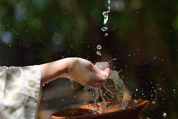 Image showing splashing fresh water on woman hands