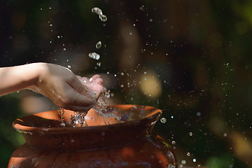 Image showing splashing fresh water on woman hands