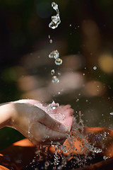 Image showing splashing fresh water on woman hands