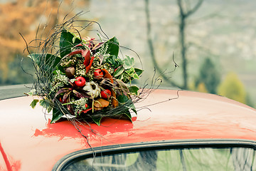 Image showing Autumnal bouquet on the top of retro car