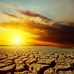 Image showing dramatic sunset over drought earth