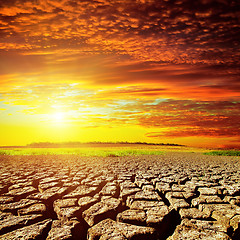 Image showing red sunset over cracked desert