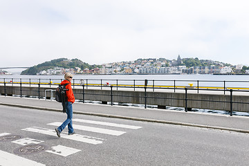 Image showing Woman with backpack crossing the street