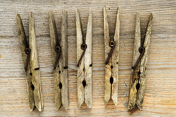 Image showing dirty old clothespins on a wooden board