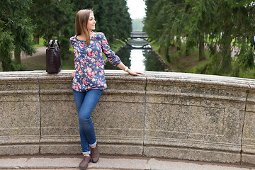 Image showing Beautiful young girl on the old stone bridge