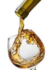 Image showing Cognac pouring into glass with splash isolated on white backgrou