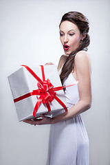 Image showing Young smiling woman holding gift