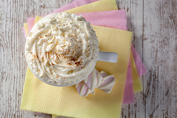 Image showing hot chocolate with marshmallows and cream on wooden background