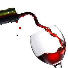 Image showing Pouring red wine in glass goblet isolated on white