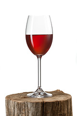 Image showing Glass of red wine on stump isolated on white