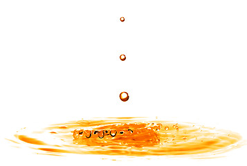 Image showing drop falling into orange water with splash isolated on white