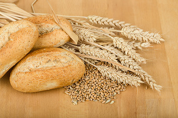 Image showing roll on wooden table with ears of wheat grain