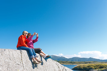 Image showing Two women taking photo of Norwegian landscape