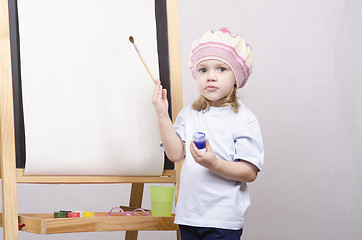 Image showing Girl artist paints on canvas