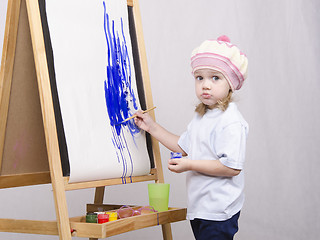 Image showing Girl artist paints on canvas