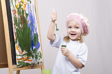 Image showing Girl artist paints on canvas