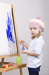 Image showing Girl artist paints on canvas