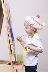Image showing Girl artist paints on canvas