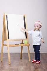 Image showing Girl artist paints on canvas