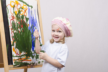 Image showing Girl artist paints on canvas