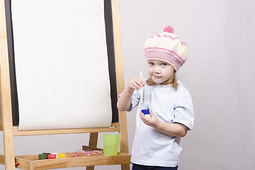 Image showing Girl artist paints on canvas