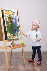 Image showing Girl artist paints on canvas