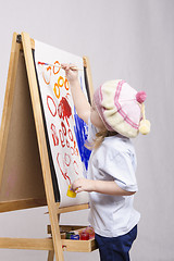 Image showing Girl artist paints on canvas