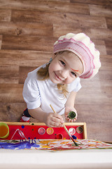 Image showing Girl artist paints on canvas